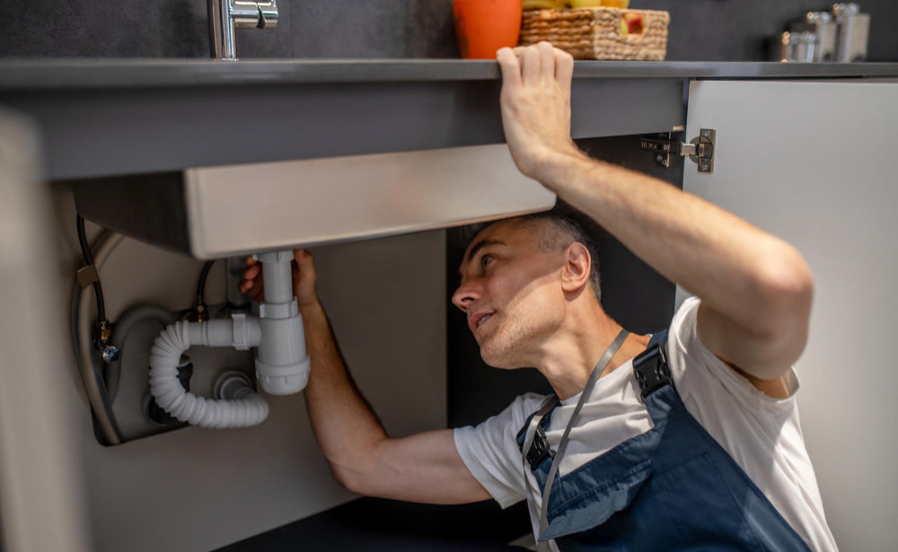 Plumber Fixing Kitchen Sink Garbage Disposal