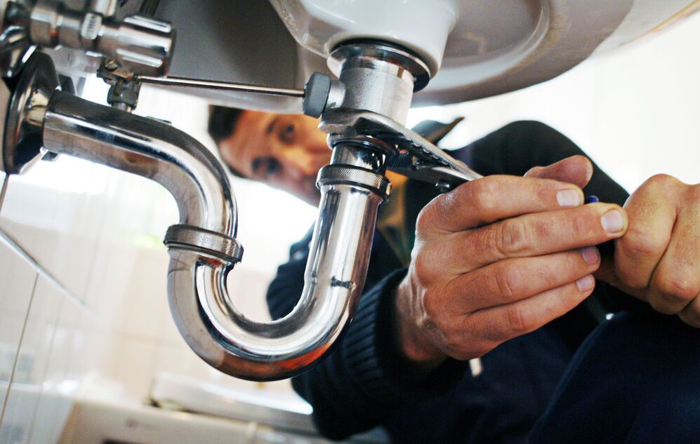 Close Up Of Plumber Repairing Sink With Tool In Bathroom